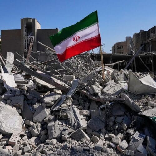 Iranian flag amidst rubble and destruction
