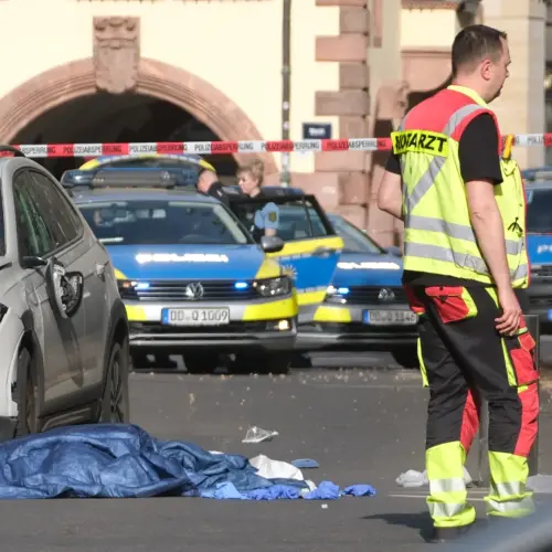 Rescue workers stand next to a damaged car that has crashed into several people in Leipzig, Germany, Monday, May 4, 2026.