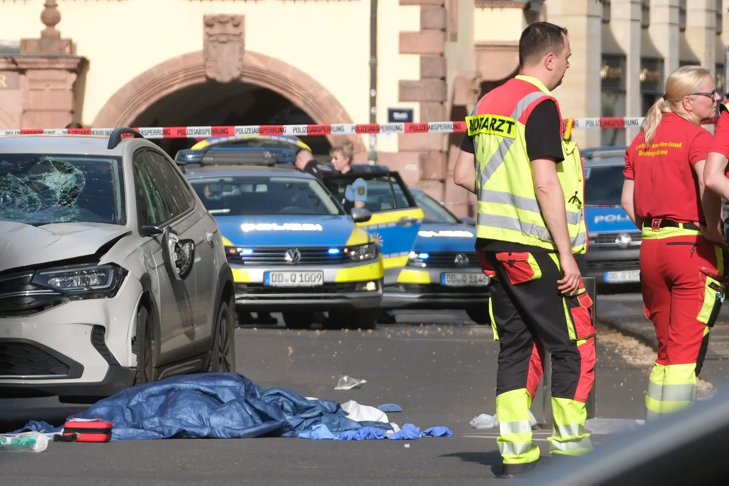 Rescue workers stand next to a damaged car that has crashed into several people in Leipzig, Germany, Monday, May 4, 2026.