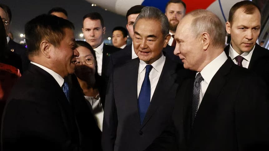 Russian President Vladimir Putin greets Chinese officials, including Foreign Minister Wang Yi after he landed in Beijing.