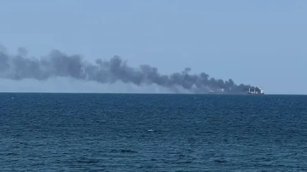Smoke rises from a vessel on fire.