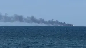 Smoke rises from a vessel on fire.